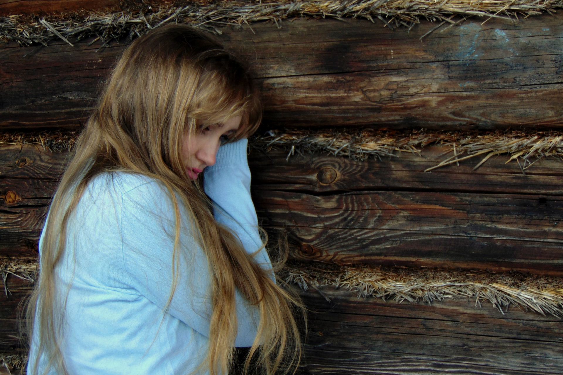 woman leaning on black wooden wall