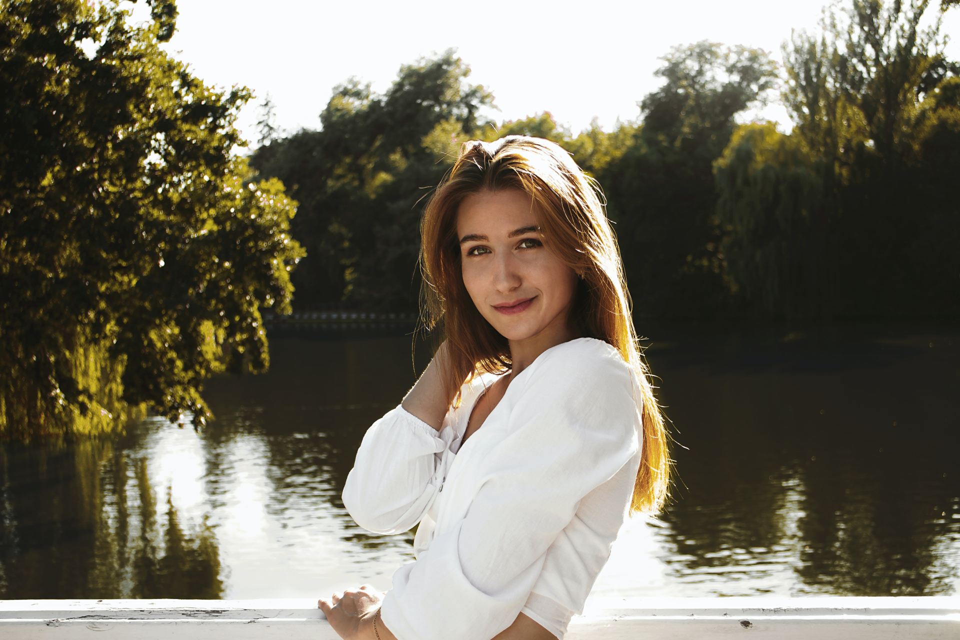 woman in white long sleeve shirt standing near body of water during daytime
