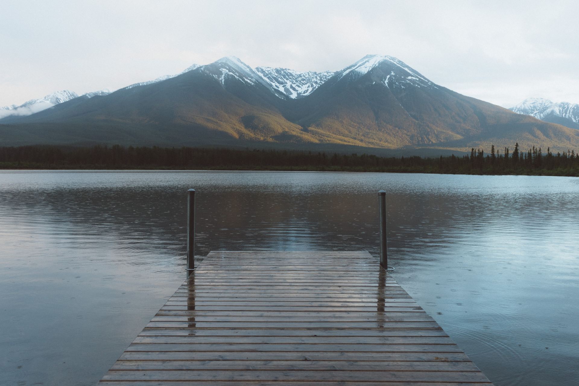snow-capped mountain at the horizon viewed from lake dock
