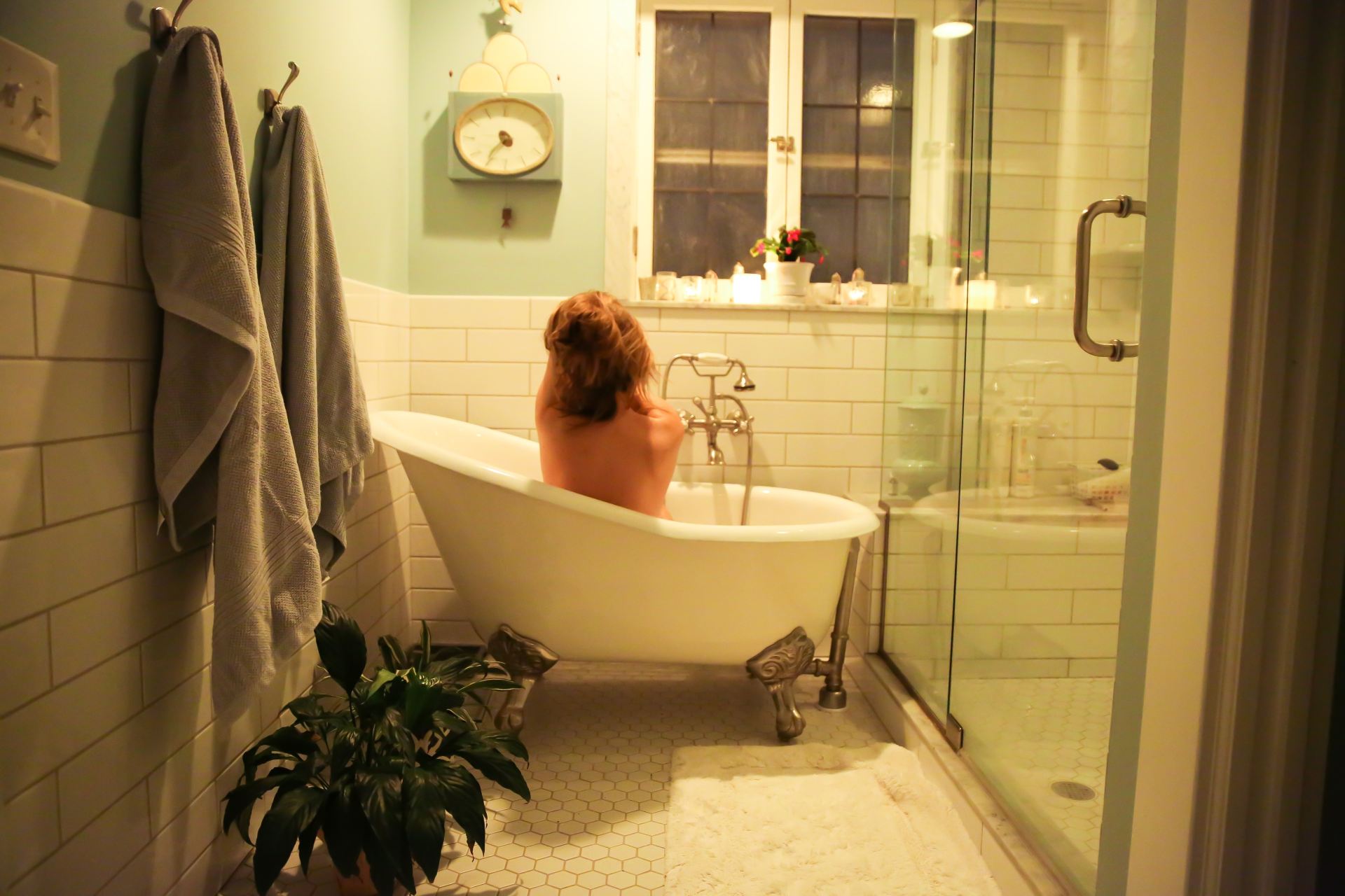 woman in bathtub near white bathtub
