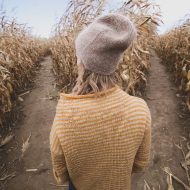woman standing in brown field while looking sideways