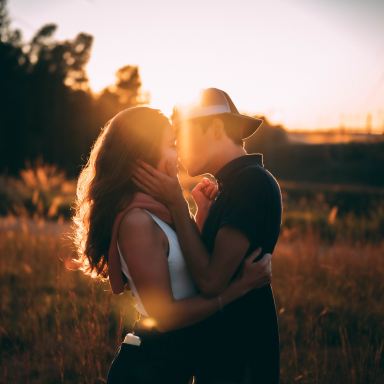 man and woman kissing during sunset