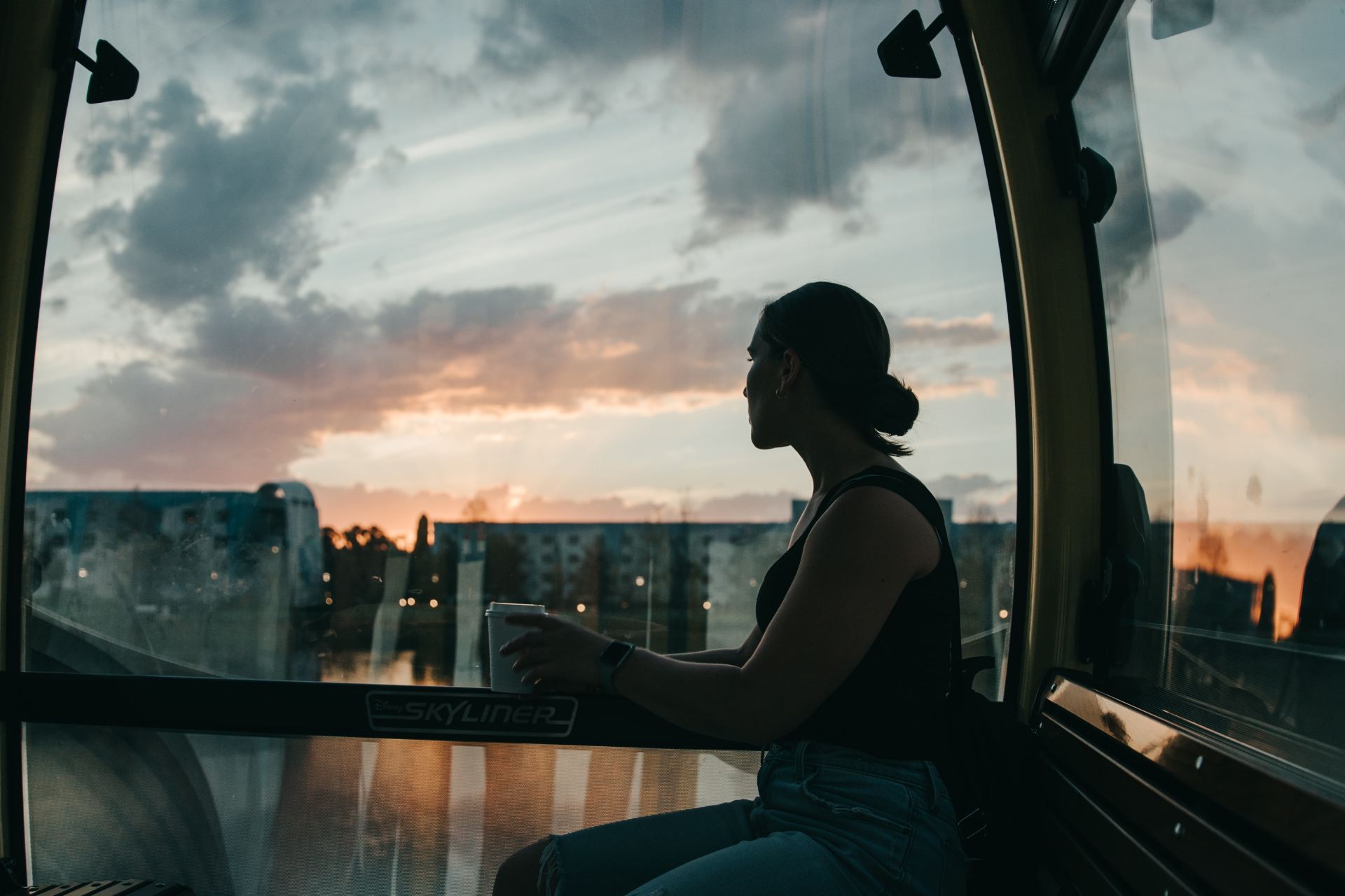 woman in black tank top sitting on window during daytime