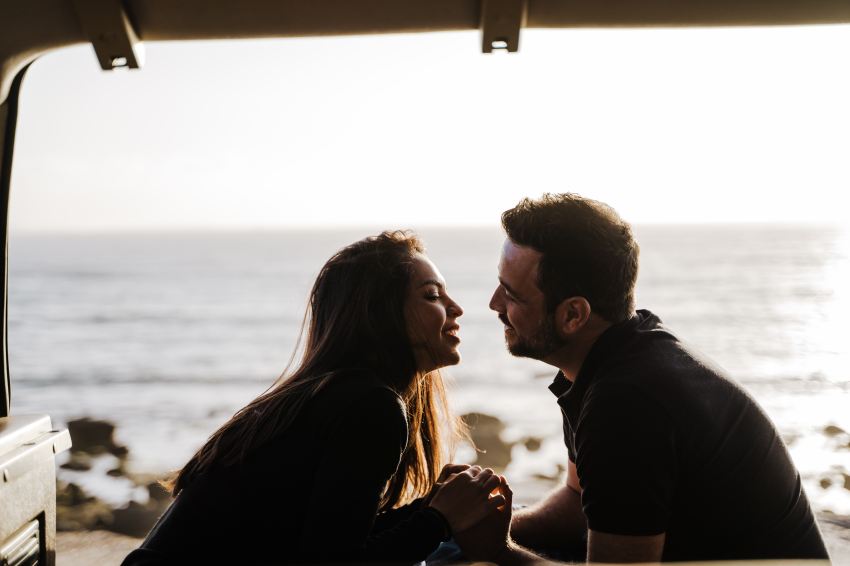 man and woman standing near body of water during daytime