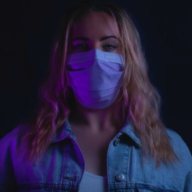 woman in purple denim jacket with white mask