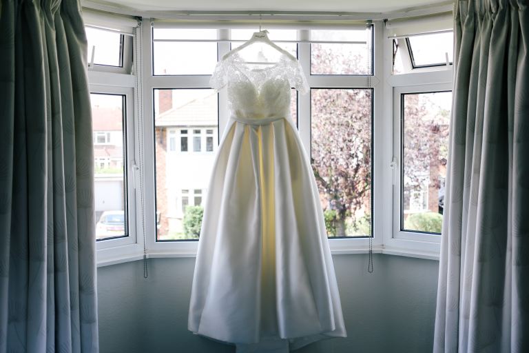 women's white sleeveless gown near window