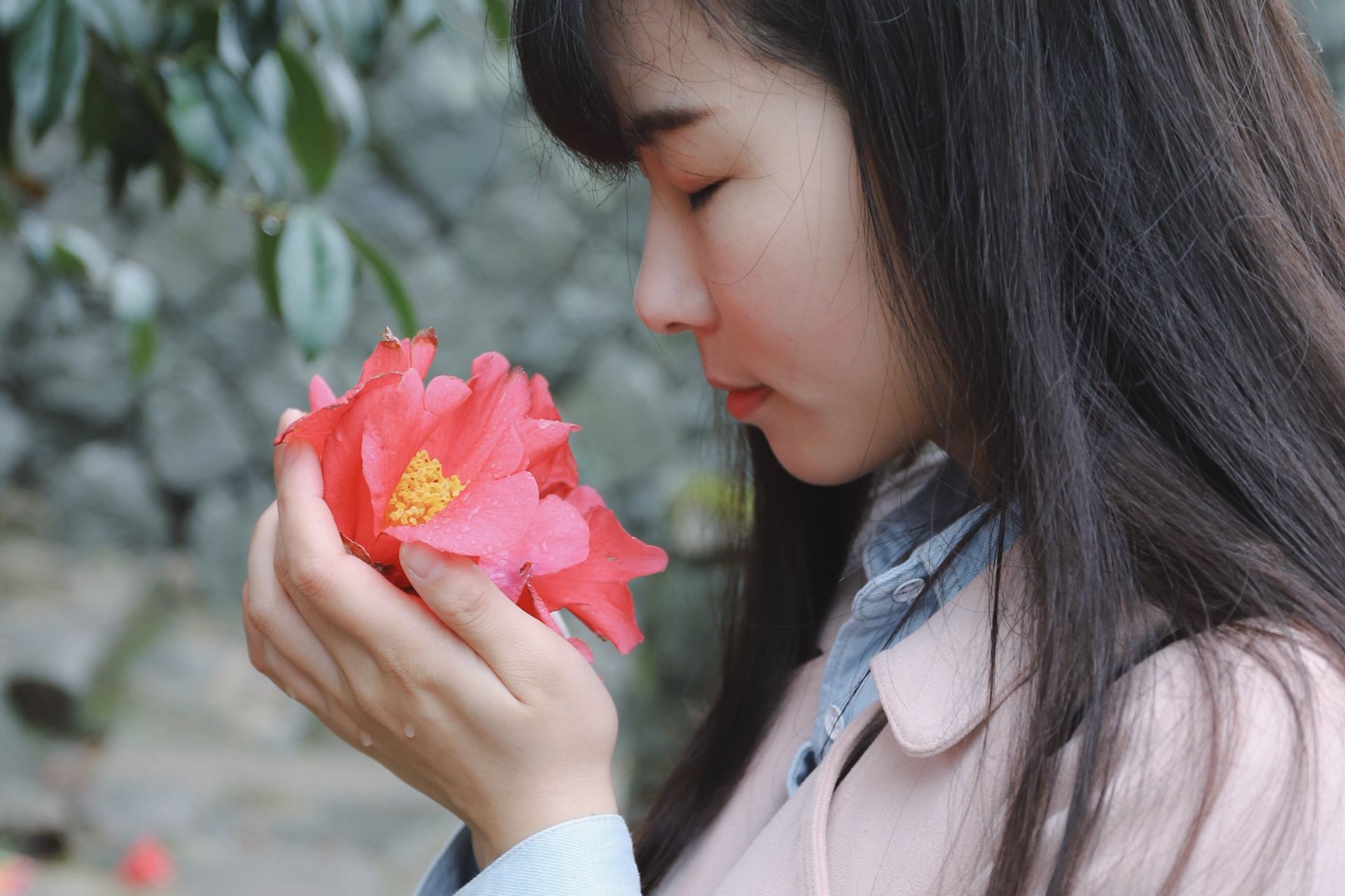 woman sniffing flower on her hands