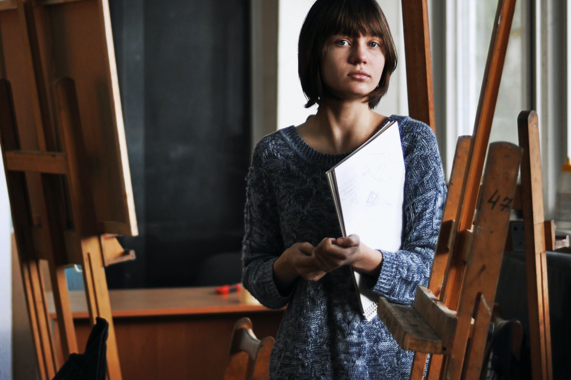 woman holding art book inside art studio