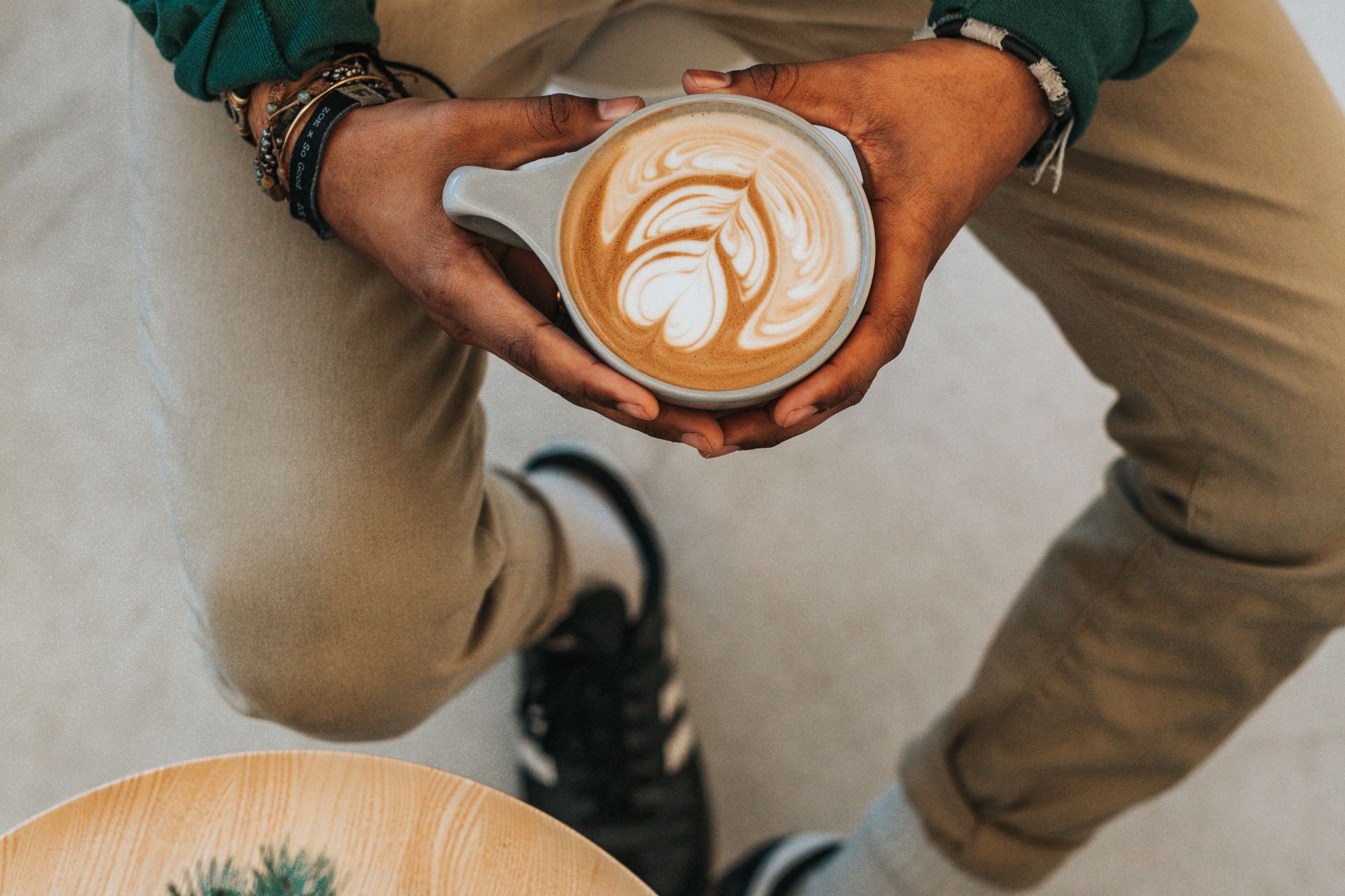 person holding cup with designed coffee