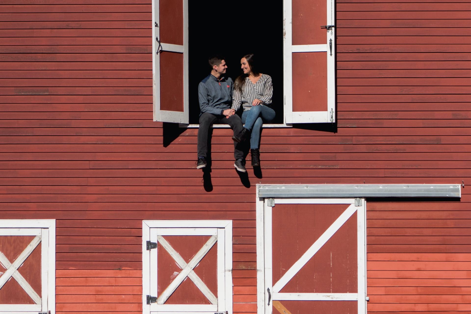 man and woman sitting in stable window