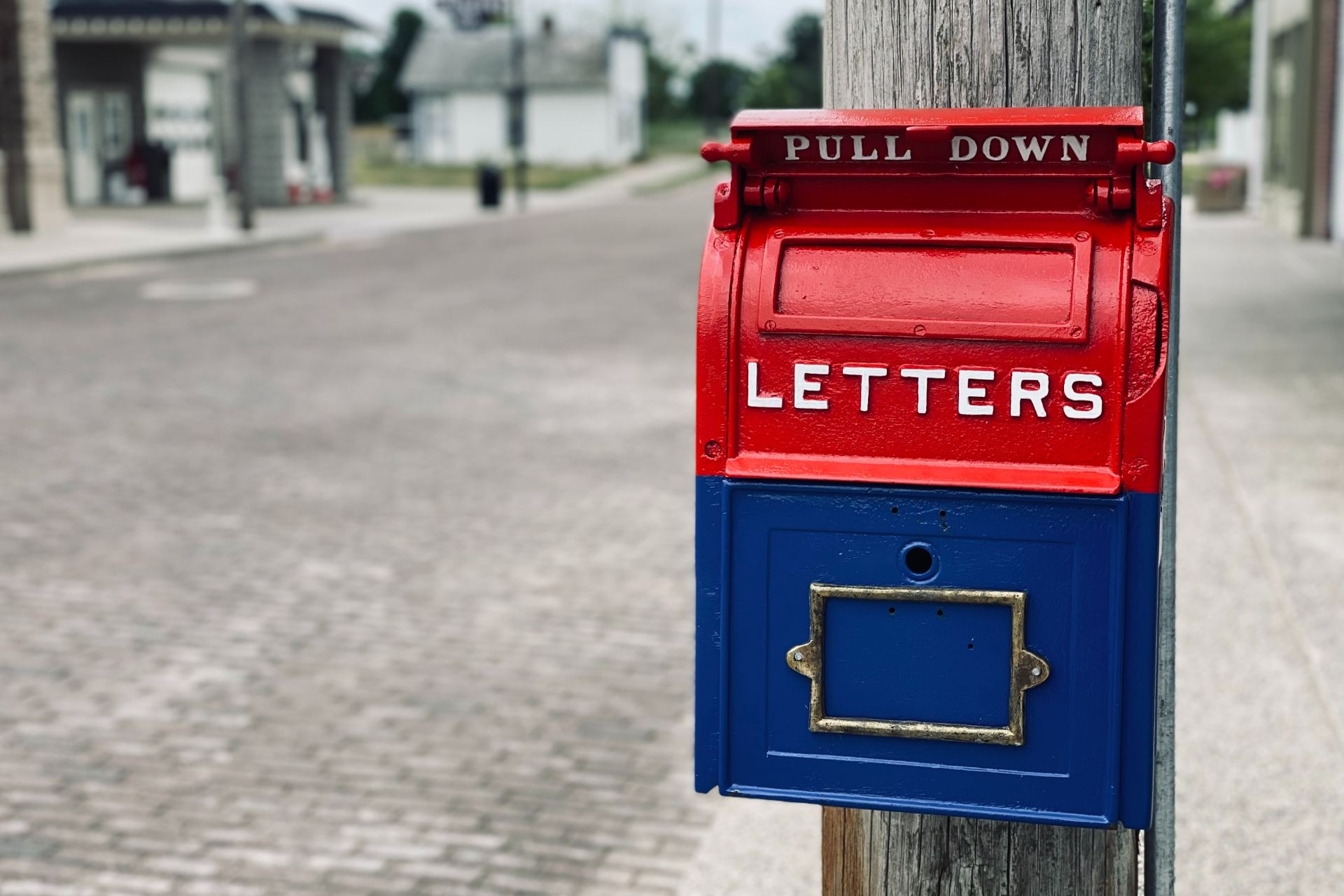 red mail box on brown wooden post