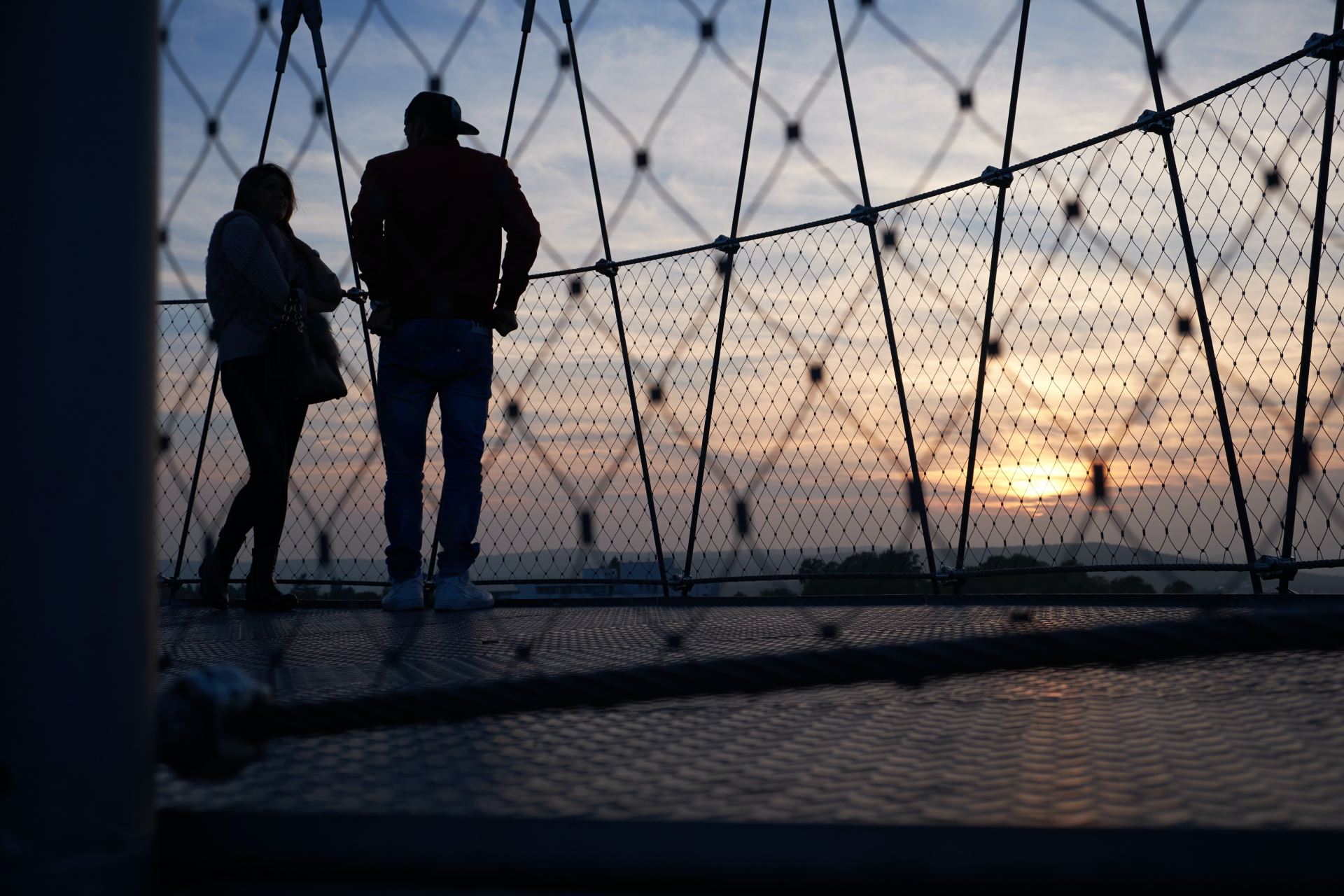 man and woman standing on hanging bridge
