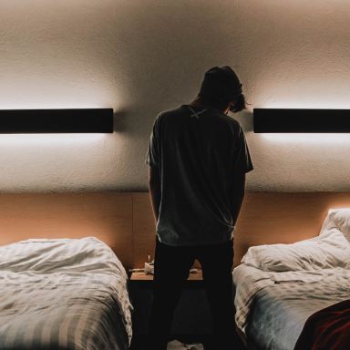 silhouette of person standing between two beds