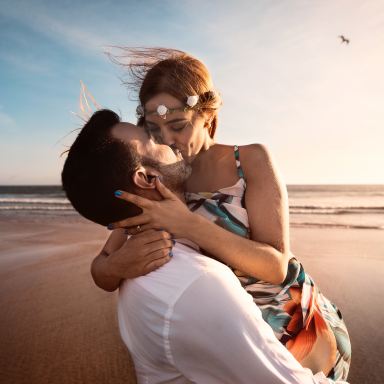 man and woman kissing on beach