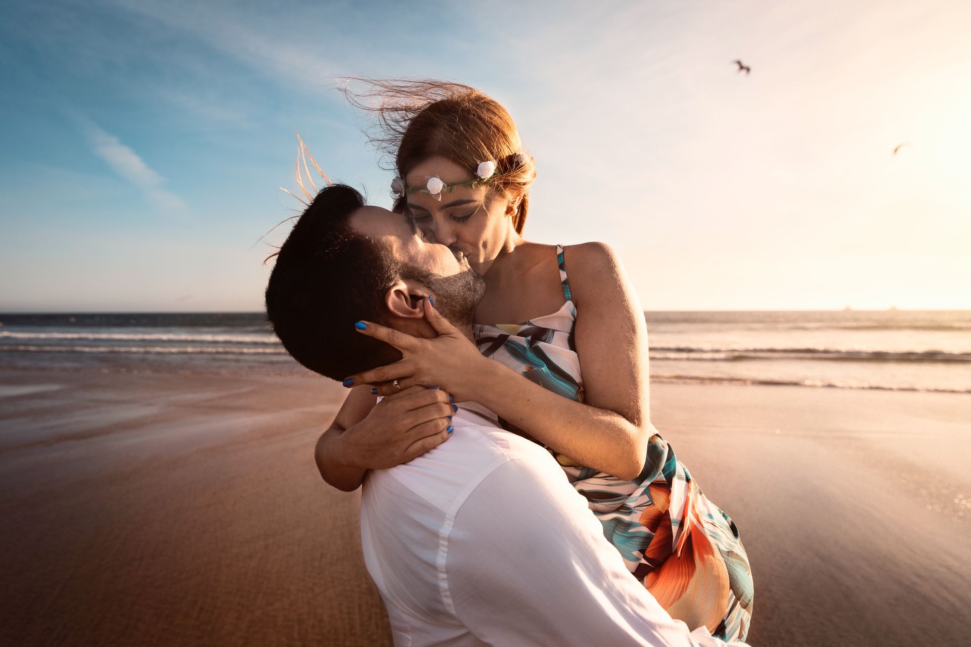 man and woman kissing on beach