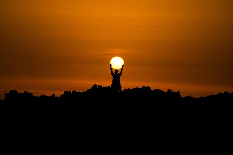 silhouette of person holding sun