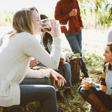 woman sitting near people while drinking